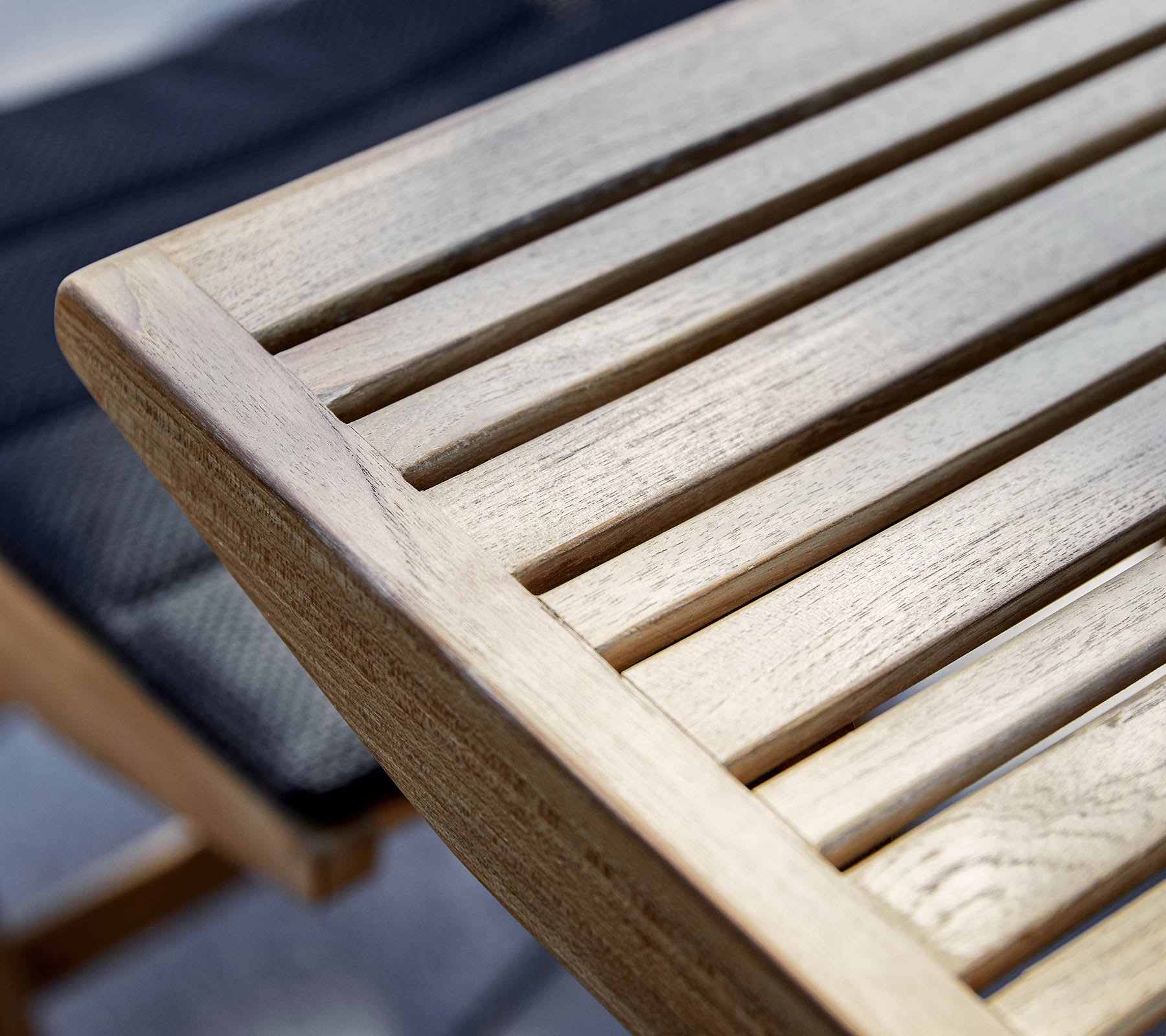 Gros plan d'un bord en bois avec un design à lames, mettant en valeur le grain naturel et la texture du bois.