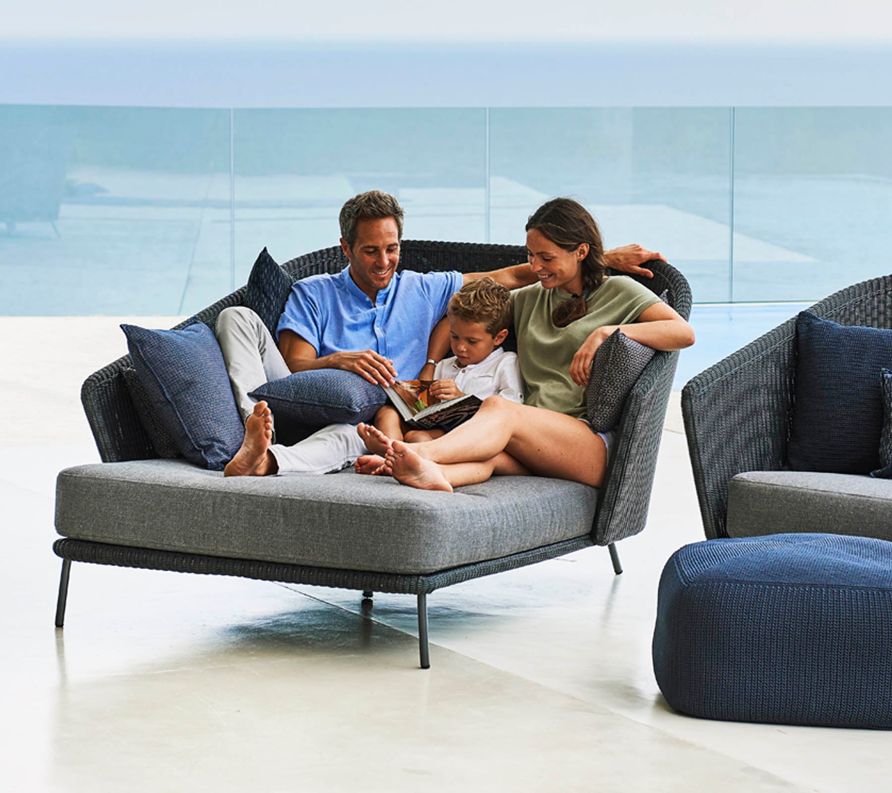 La famille profite de moments de qualité ensemble, lisant un livre sur un fauteuil élégant et confortable avec des coussins doux.