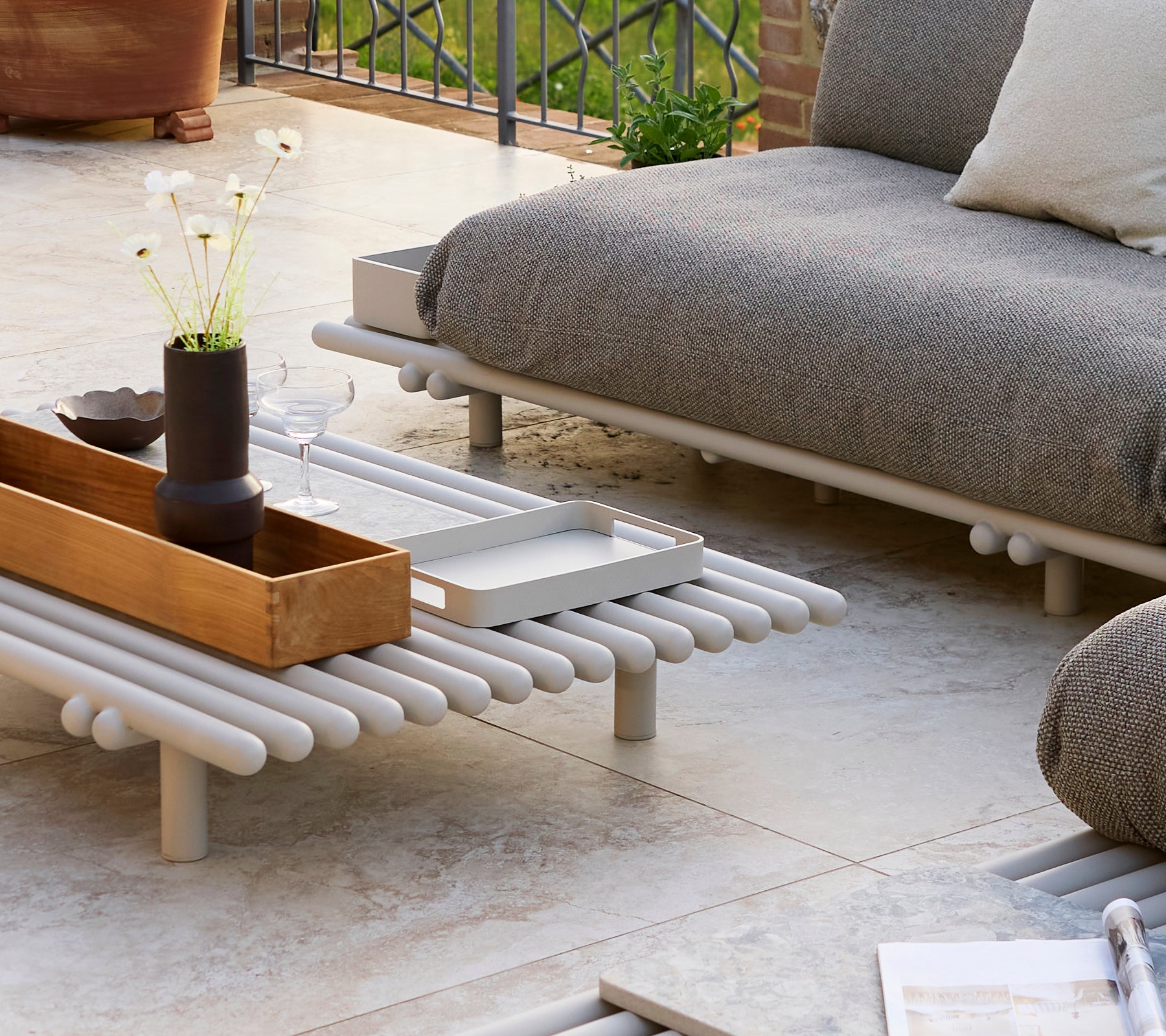 Un petit plateau rectangulaire sur une table basse plateforme avec des objets décoratifs et un design minimaliste.