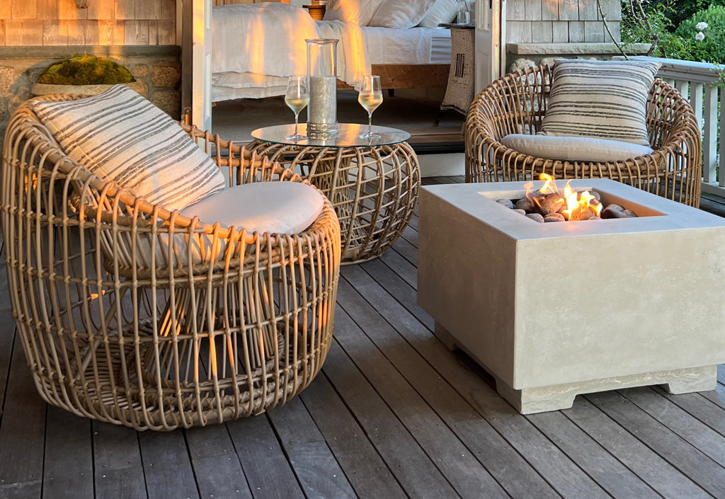 Veranda at sunset with two round lounge furniture and a round coffee table with glass tabletop