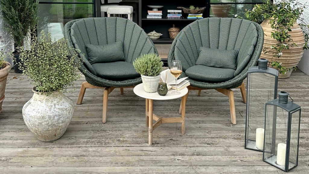 Two dark green Peacock outdoor lounge chairs with Twist white round side table