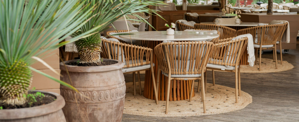 Intérieur du restaurant Josefina à Stockholm avec des chaises de salle à manger Ocean modernes de Cane-line, décor de palmiers.