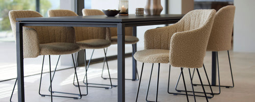 Chaises de salle à manger élégantes avec une texture tissée et de sleek pieds noirs entourant une table moderne, améliorant l'expérience culinaire.