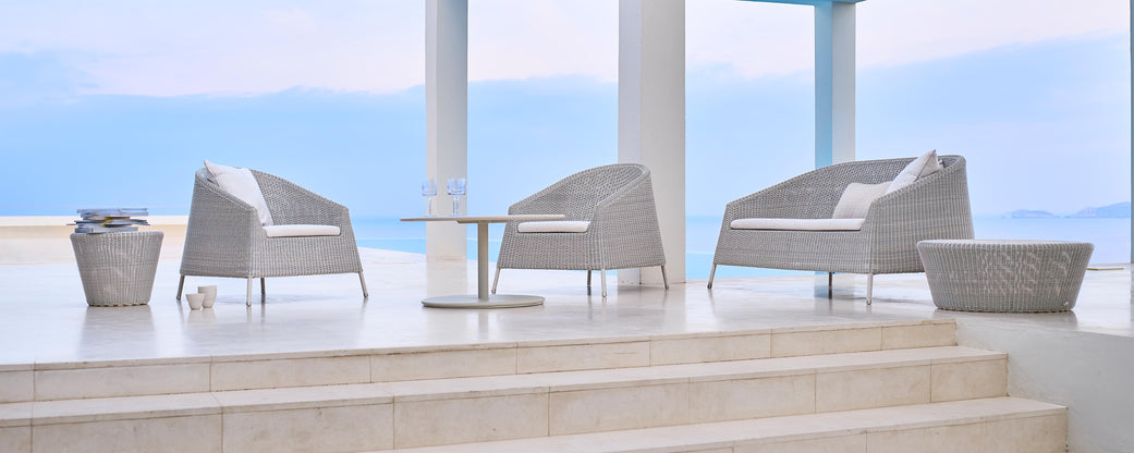 Stylish seating area featuring two modern chairs and a table, set against a serene backdrop. Perfect for relaxation and leisure.