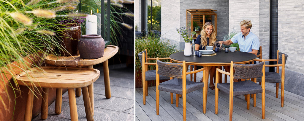 Two people enjoying a meal at a stylish wooden dining table surrounded by greenery, with decorative planters and seating.