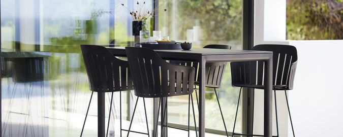 Table de bar moderne avec tabourets assortis, présentant un design épuré et une esthétique minimaliste, parfaite pour les rassemblements sociaux et la détente.