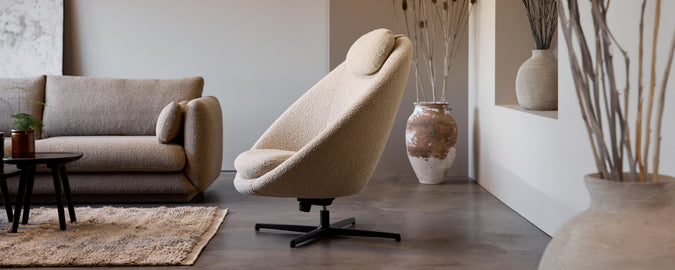 Chaise pivotante beige et canapé gris dans un cadre de salon moderne.