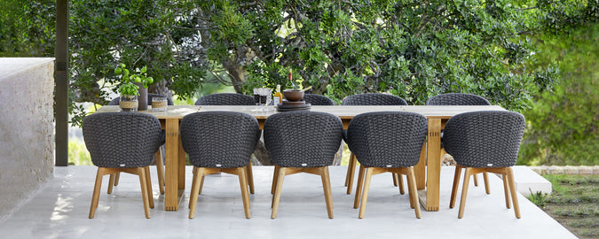 Ensemble de repas d'extérieur moderne avec des chaises noires et une table en bois.