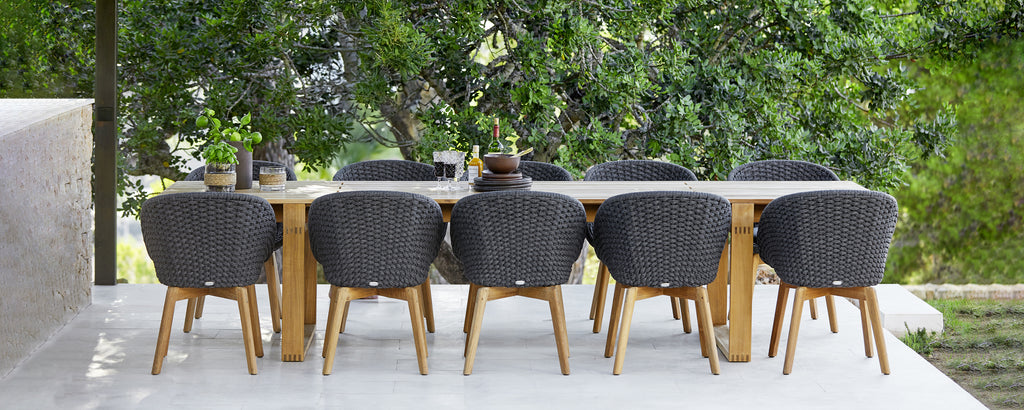 Ensemble de repas d'extérieur moderne avec des chaises noires et une table en bois.