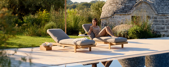 Chaises longues grises contemporaines près d'une piscine dans un cadre extérieur.