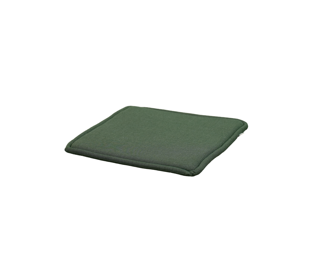 Coussin vert clair placé sur une surface plane.