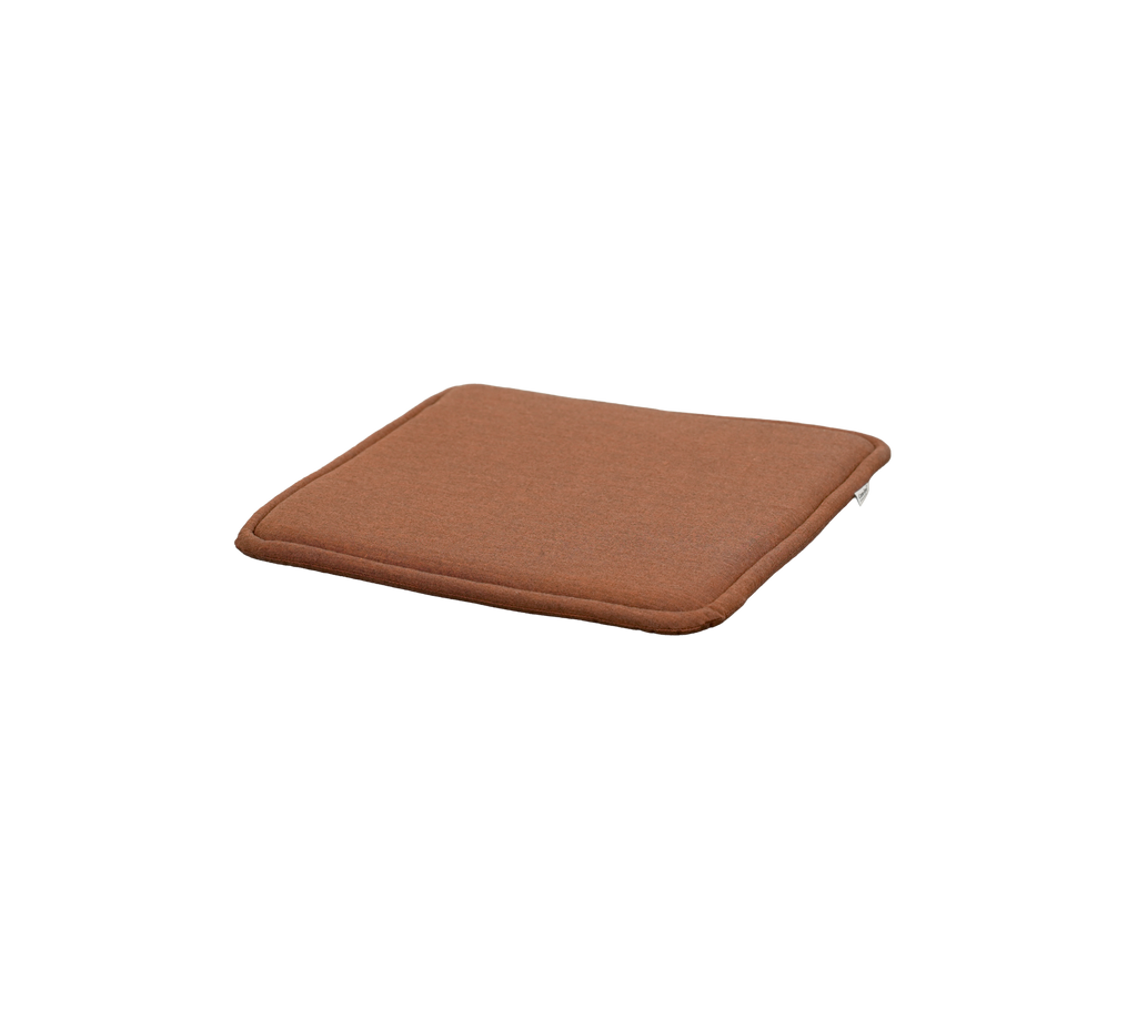 coussin rouge désert avec une forme carrée et une épaisseur subtile.