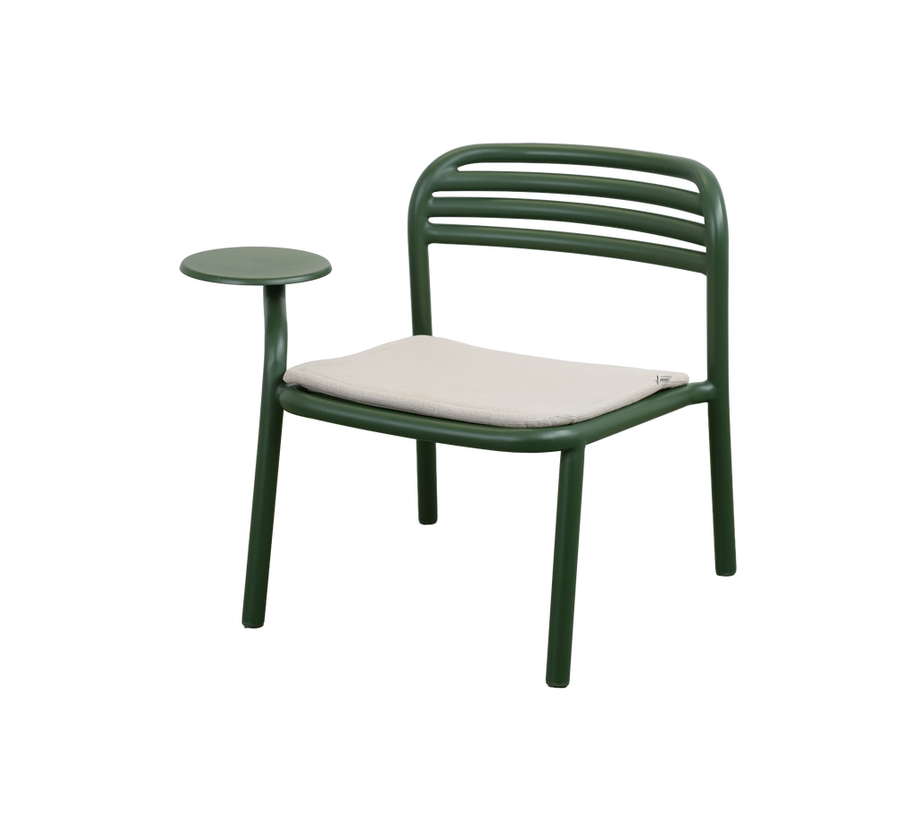 Chaise vert foncé avec un coussin sable et une table d'appoint.