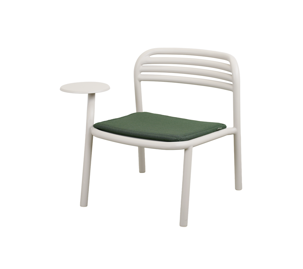 Chaise moderne avec coussin vert clair et table d'appoint.