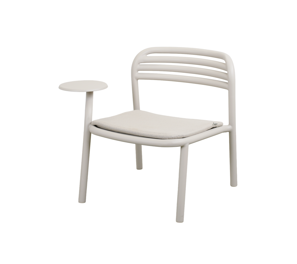 Chaise moderne avec un coussin en sable et une petite table d'appoint.