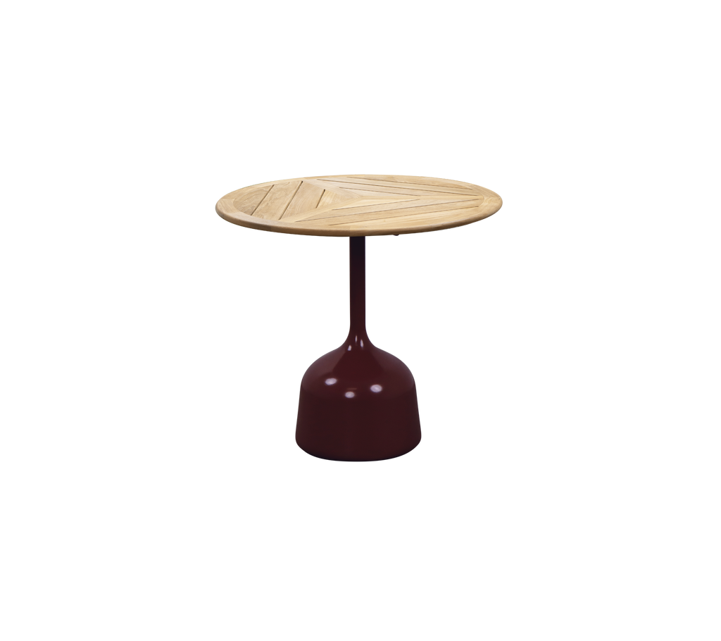 Table bordeaux avec un plateau rond en teck présentant un design lamelé.