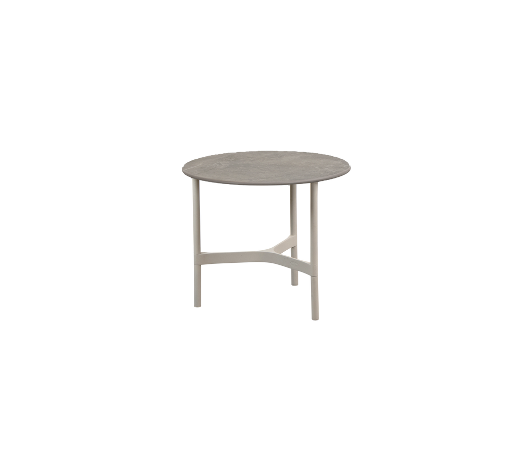 Table ronde dans une couleur neutre avec un design simple.