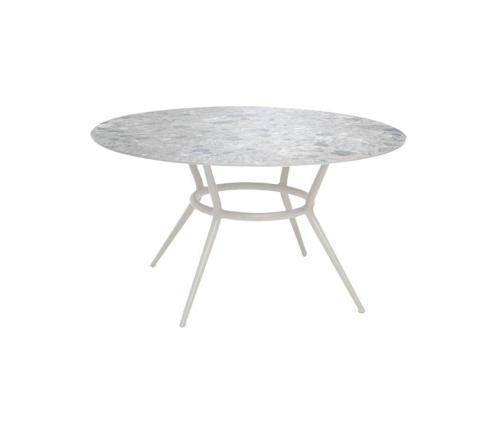 Table ronde avec un plateau multicolore et une base claire.