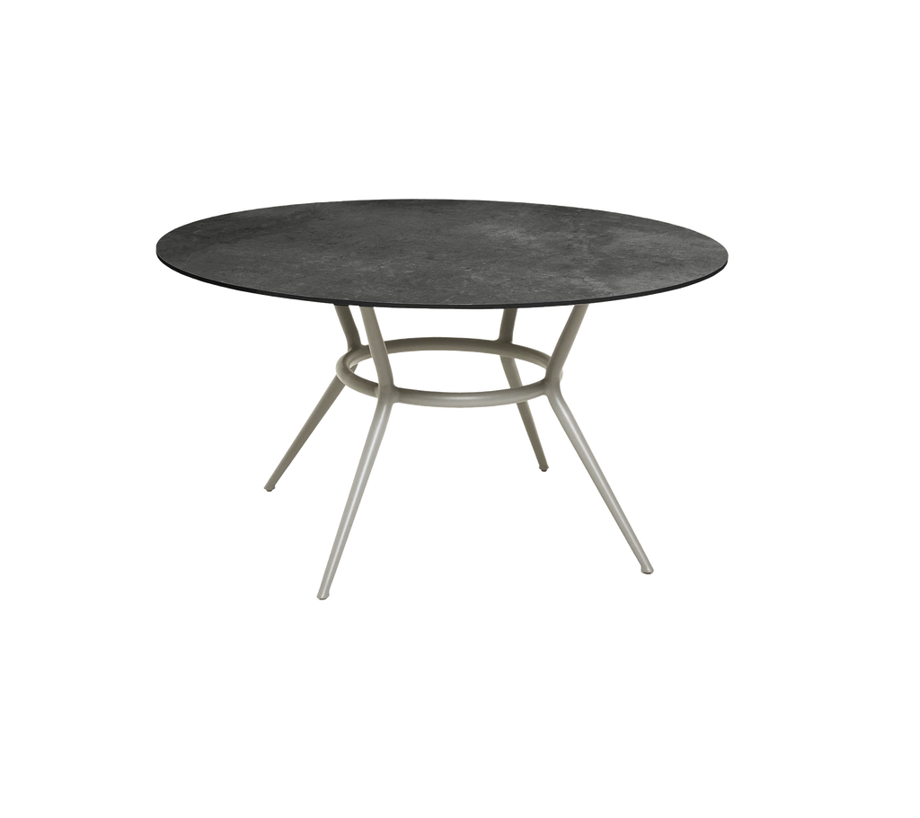 Table ronde gris foncé au design minimaliste et aux pieds clairs.