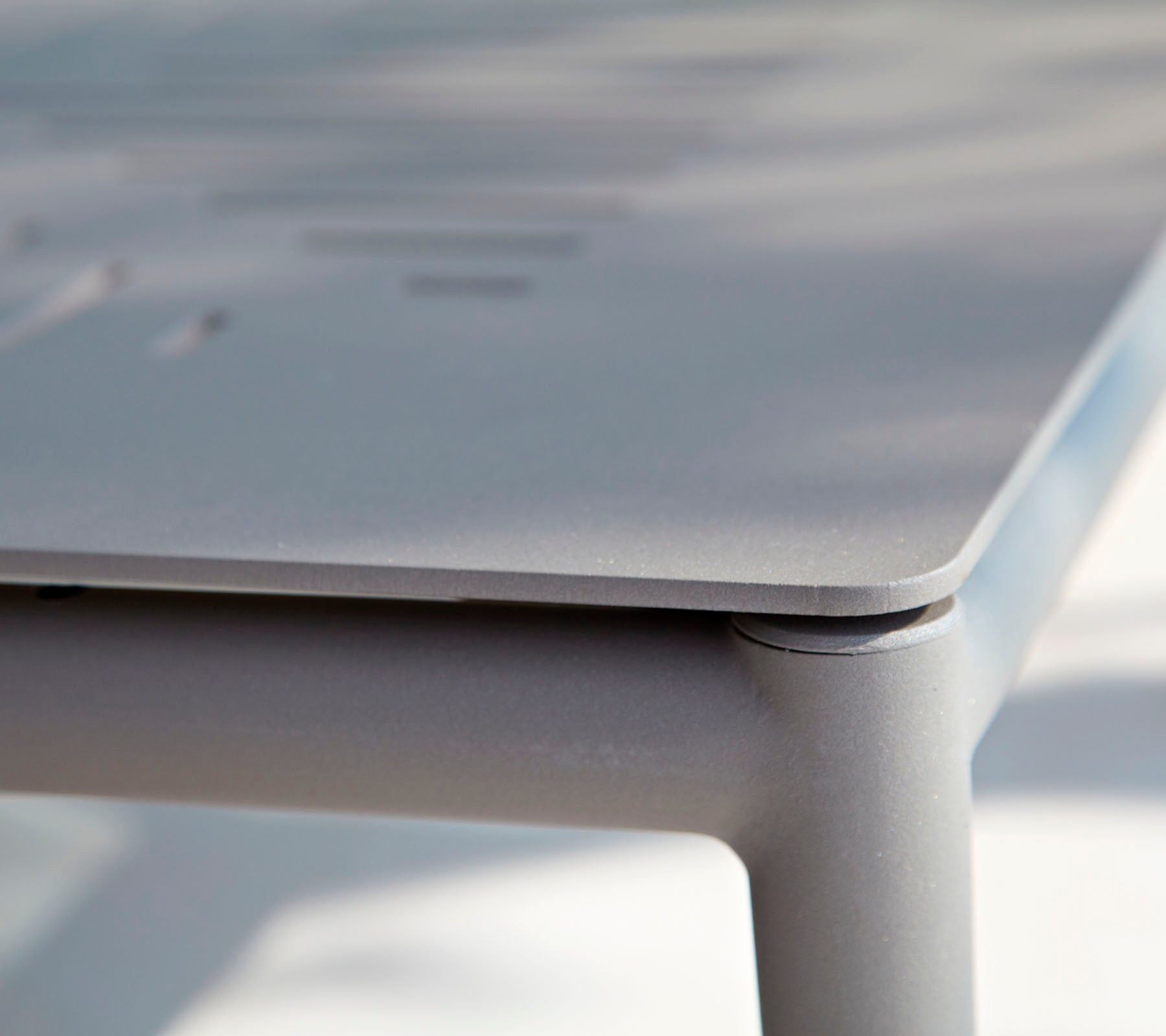 Gros plan d'une table élégante et moderne avec une surface lisse et des détails subtils. Le design met l'accent sur des lignes épurées et un style minimaliste.