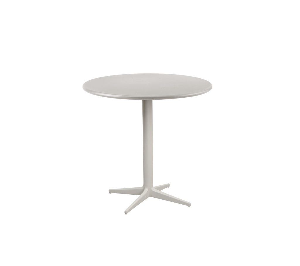 Une table ronde couleur sable avec un design minimaliste.