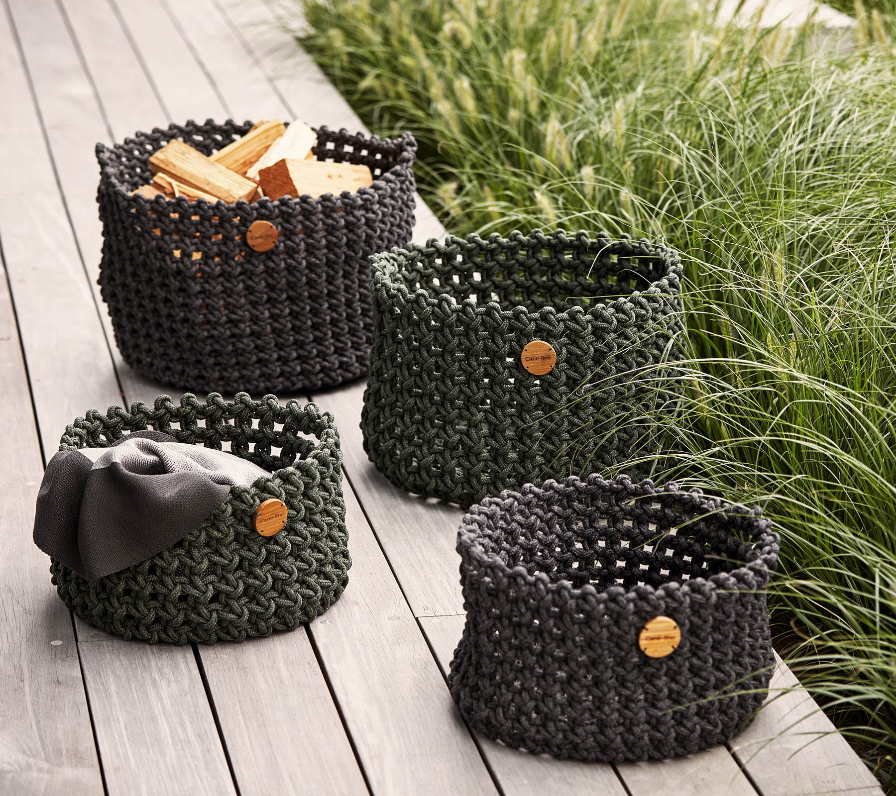 Ensemble de quatre paniers de rangement tissés de tailles variées, avec des étiquettes en bois naturel, idéals pour organiser et décorer.
