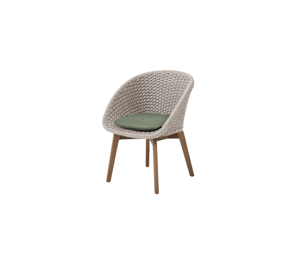 Une chaise en teck/sable moderne avec un coussin vert foncé.