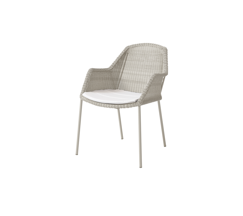 Chaise moderne avec un coussin blanc dans une couleur sable clair.
