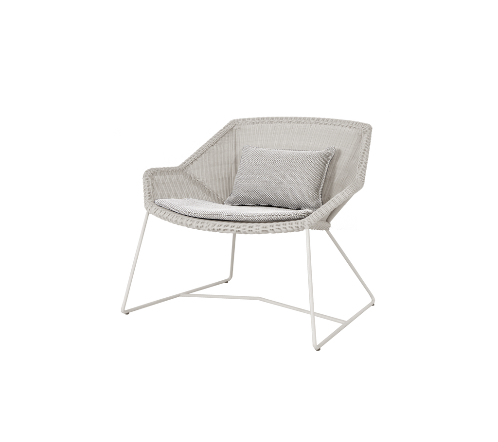 Chaise gris clair avec un coussin assorti dans un design moderne.