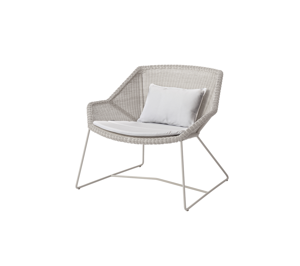 Chaise blanche moderne avec un coussin blanc dans un cadre de salon.