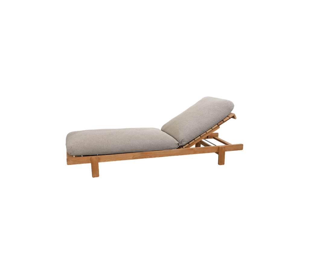 Chaise longue en teck avec coussin beige clair dans un cadre moderne.