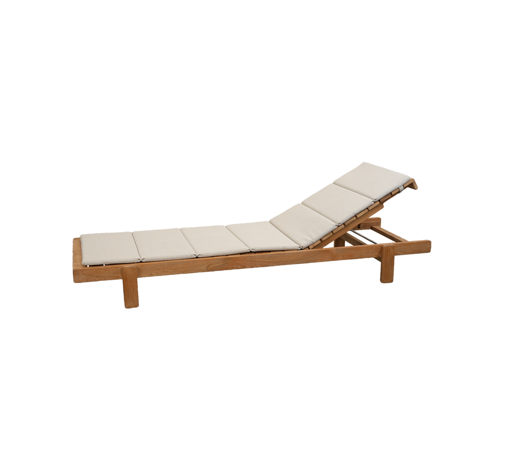 Chaise longue en teck avec coussin sable dans un cadre extérieur moderne.