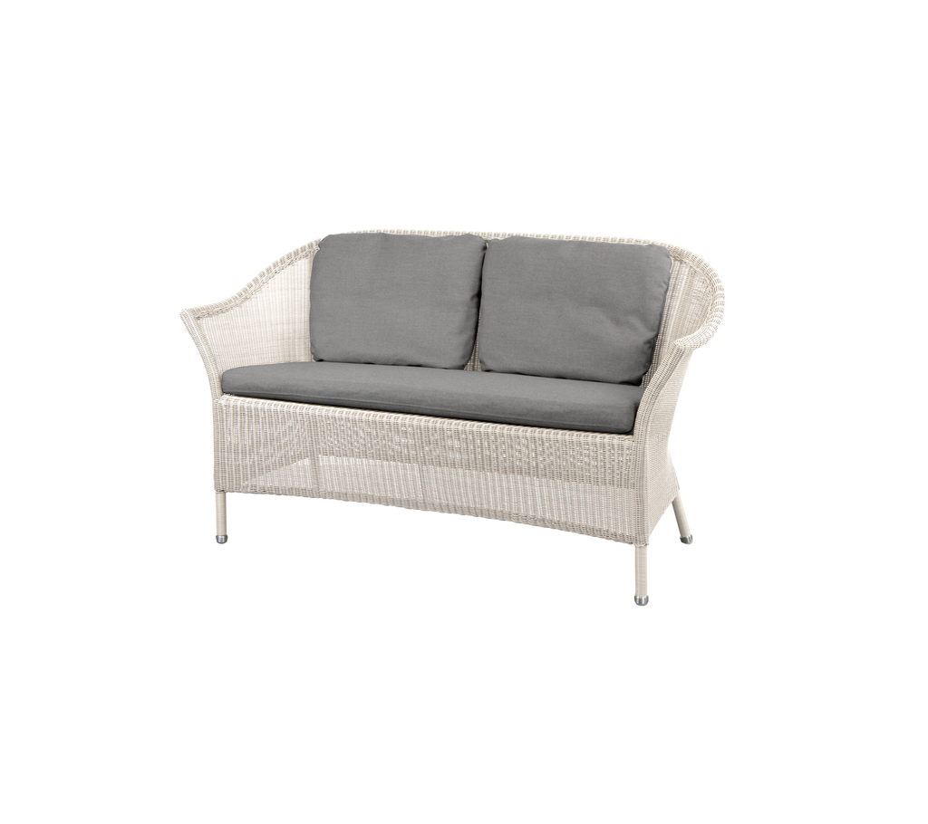 Canapé en osier blanc avec des coussins gris, offrant une option d'assise élégante et confortable. Idéal pour améliorer n'importe quel espace douillet.