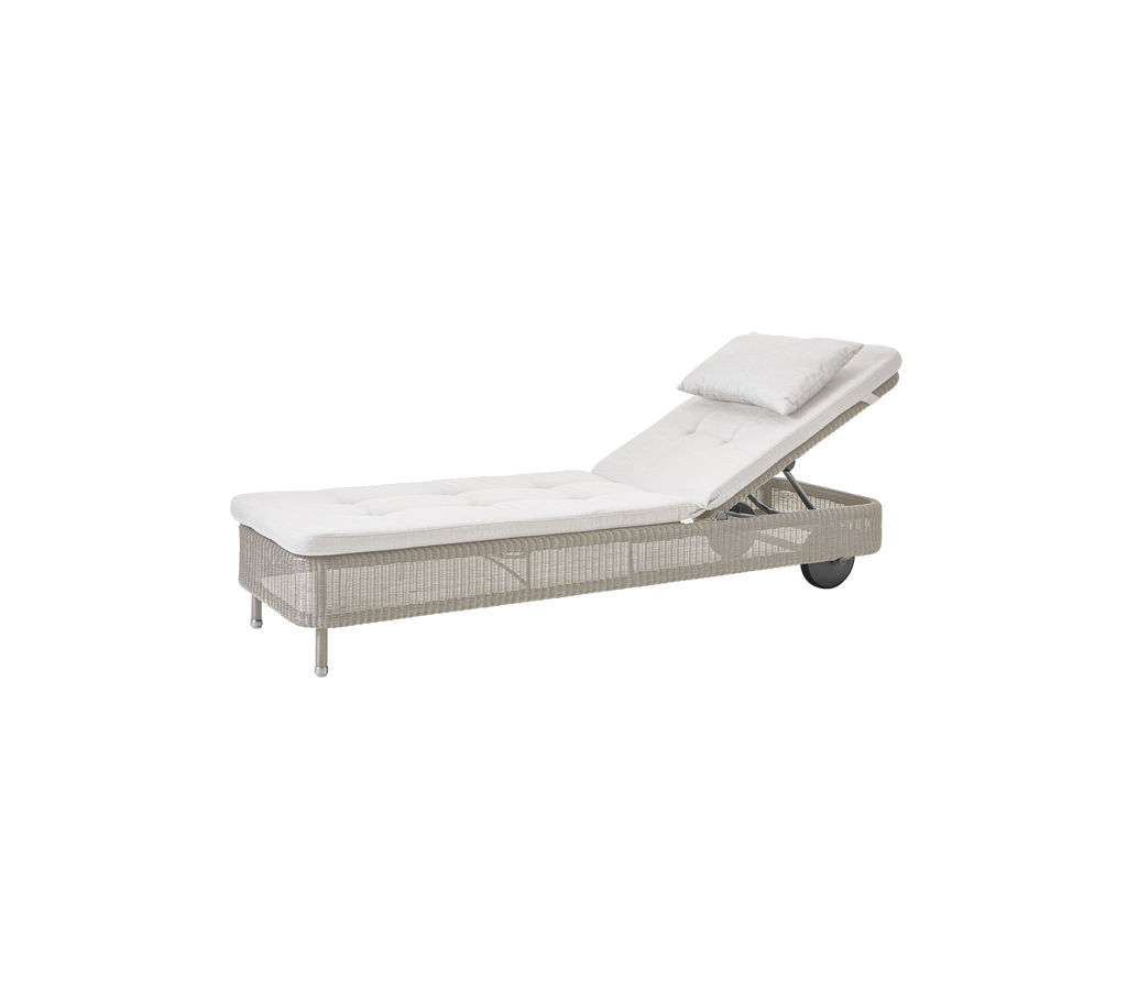 Chaise longue moderne en sable avec un coussin blanc, idéale pour se détendre à l'extérieur.