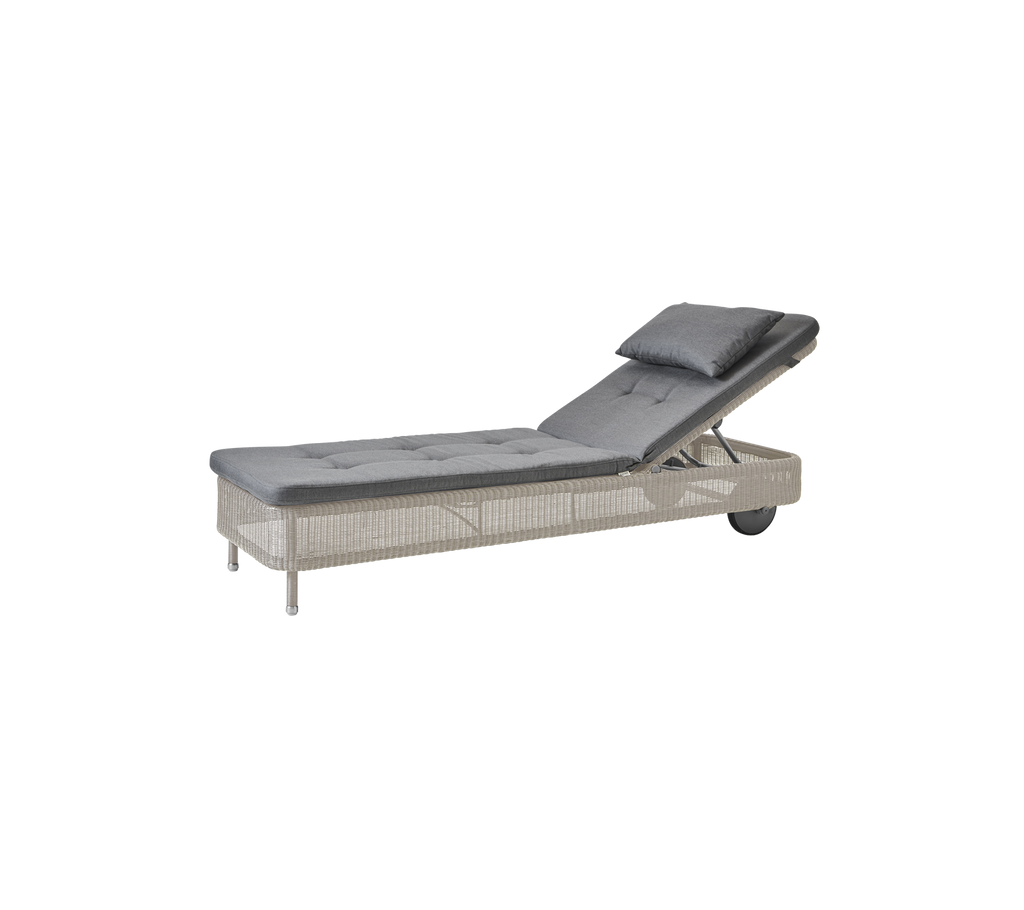 Chaise longue grise moderne avec un coussin couleur sable.