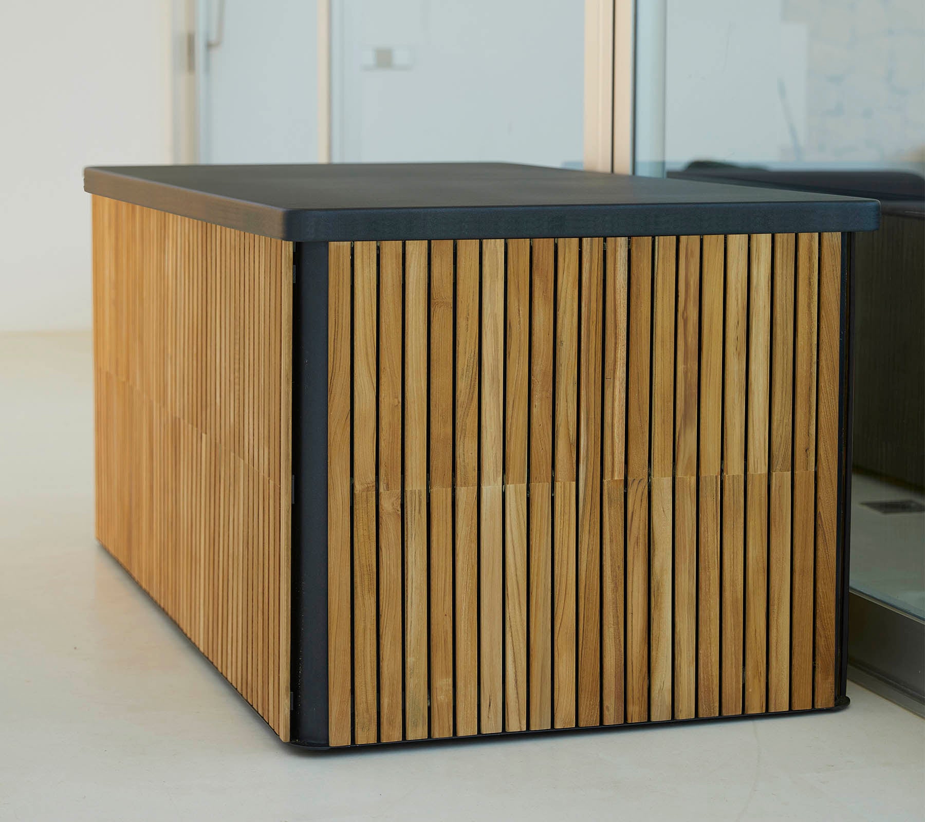 Une table en bois moderne avec des lattes verticales sur les côtés et un dessus noir élégant, offrant un design à la fois stylé et fonctionnel.
