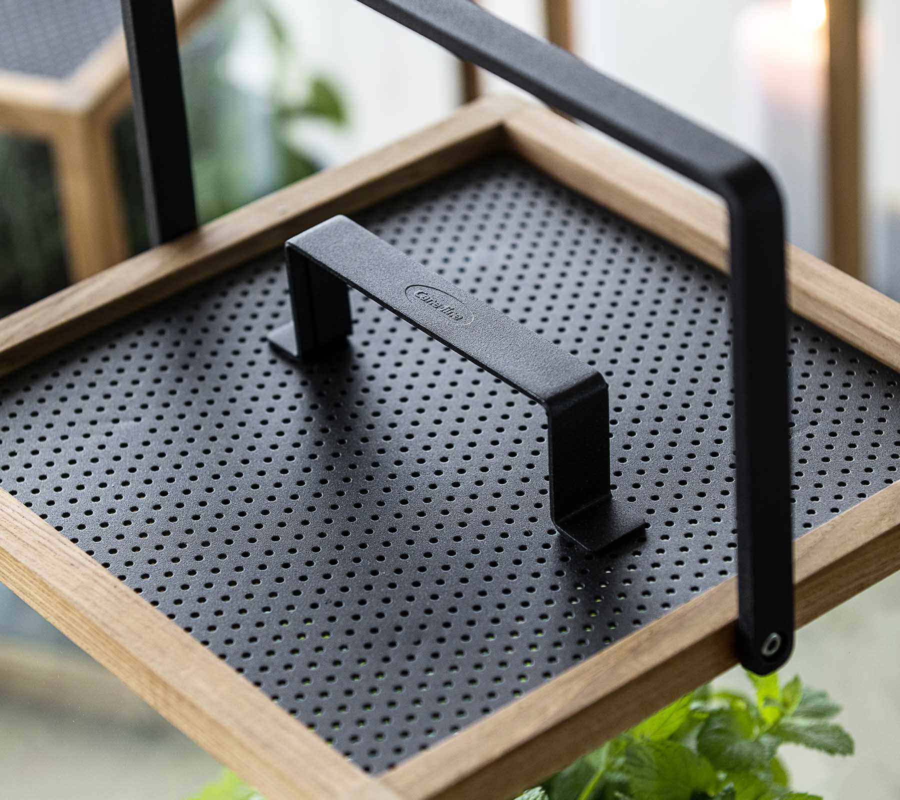 Plateau décoratif avec une surface noire texturée et une poignée robuste, parfait pour présenter des plantes ou servir des articles.