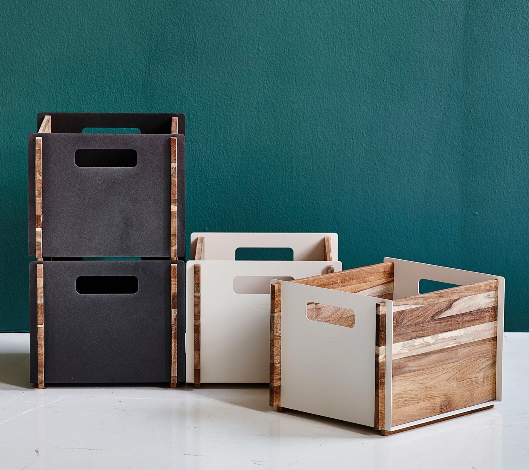 Boîtes de rangement empilables élégantes en noir, blanc et finition bois naturel, dotées de poignées découpées pour une manipulation facile.