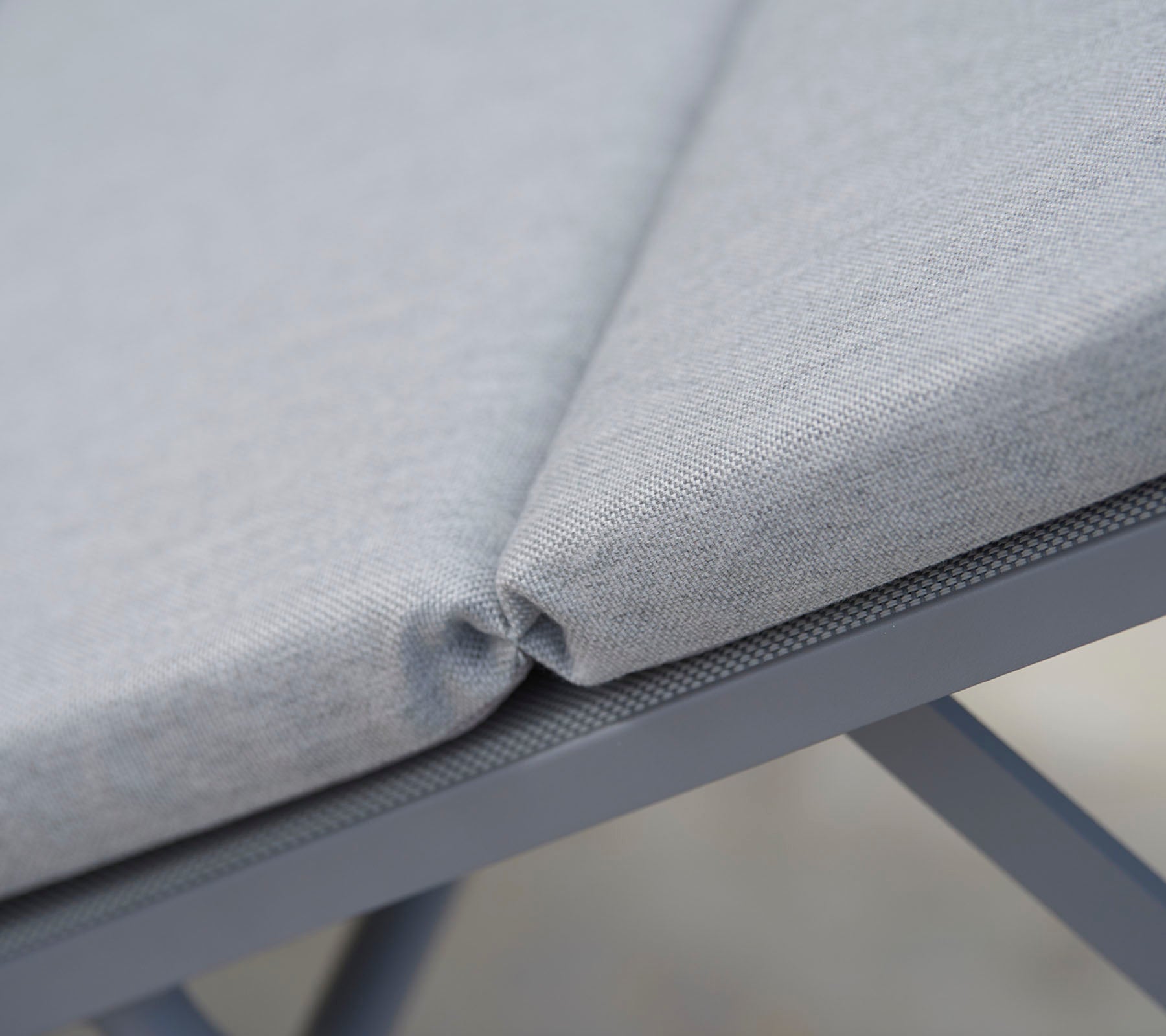 Tissu d'assise gris rembourré avec des coutures soignées, mettant en valeur un design sans couture et une structure de soutien durable.