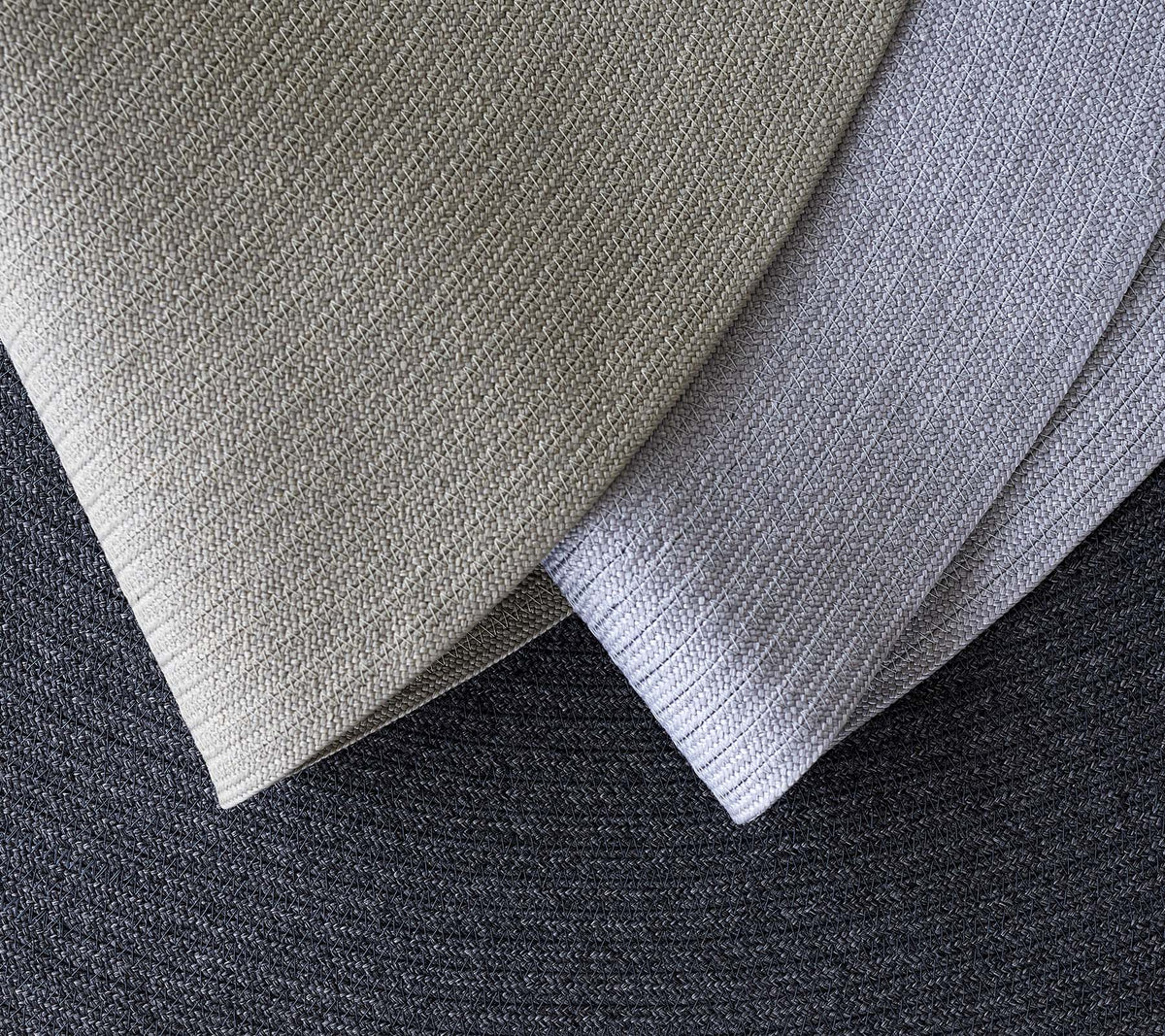 Trois tissus texturés superposés dans différentes nuances de gris, mettant en valeur différents motifs et tons pour des applications de design.
