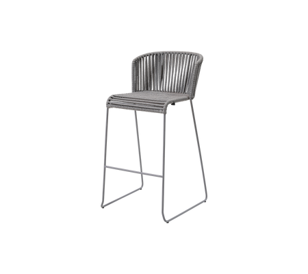 Une chaise élégante et surélevée avec un cadre en métal épuré et un design de siège tissé moderne dans une teinte neutre, idéale pour des espaces contemporains.