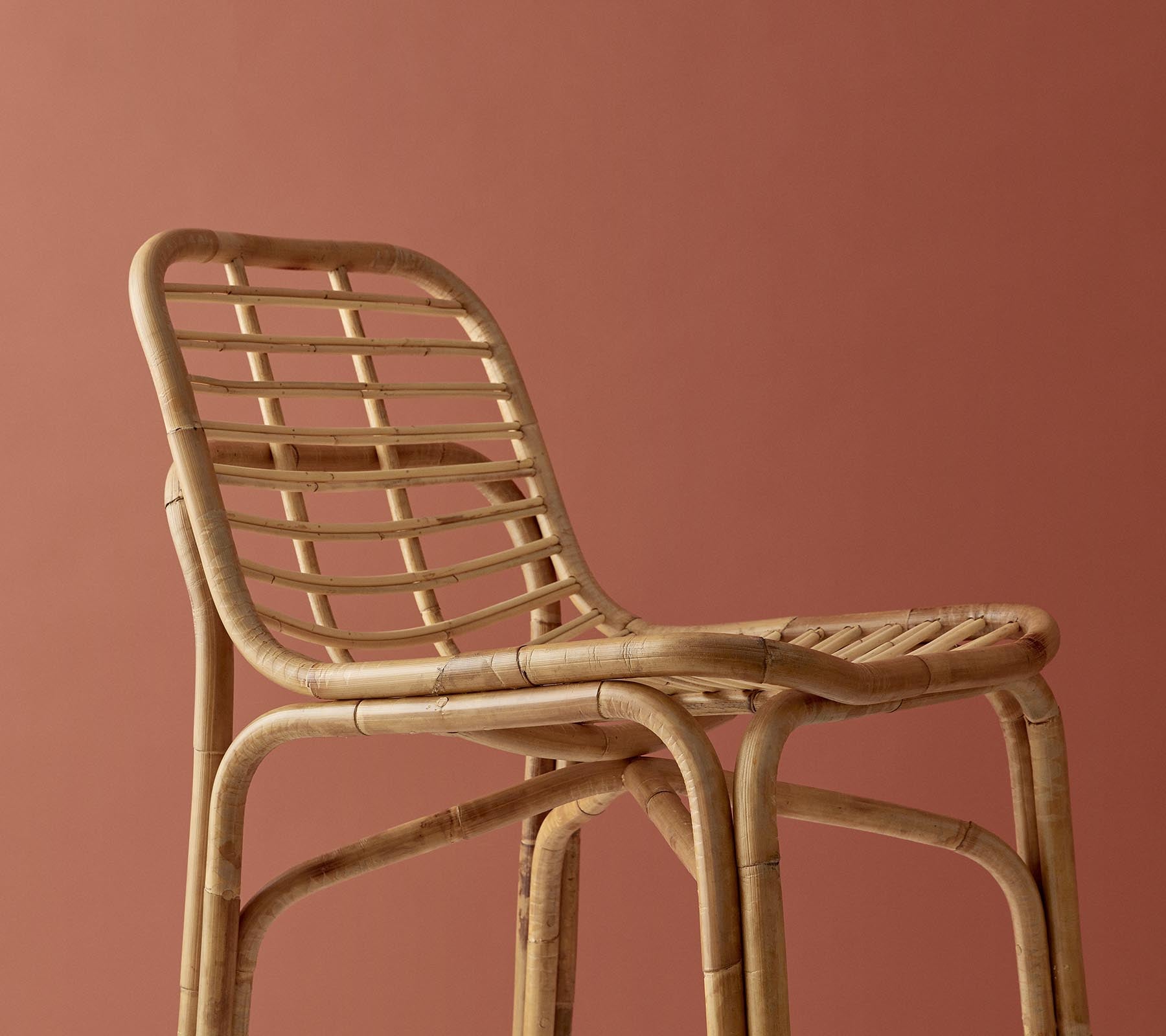 Chaise tissée élégante avec une finition naturelle, arborant un design minimaliste sur un fond atténué.