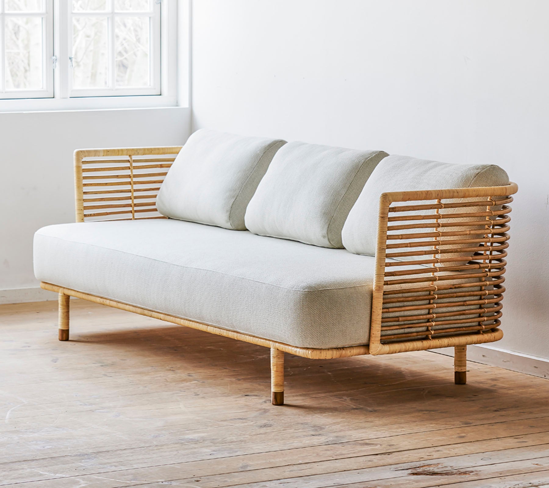 Un canapé moderne au design épuré avec un siège en tissu clair et de magnifiques accents en bois. Parfait pour des espaces contemporains.