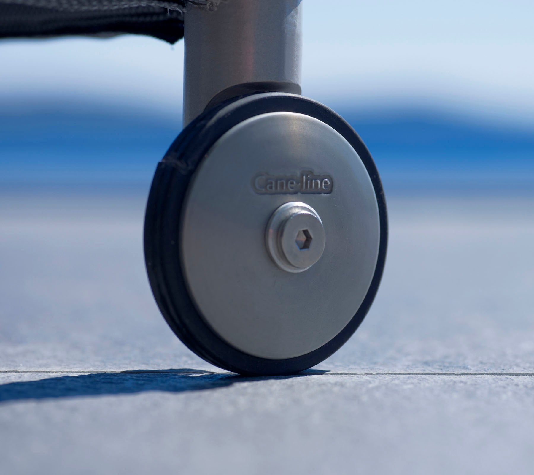 Gros plan d'une roue durable avec une finition métallique et un logo, conçue pour une mobilité facile et une stabilité sur diverses surfaces.
