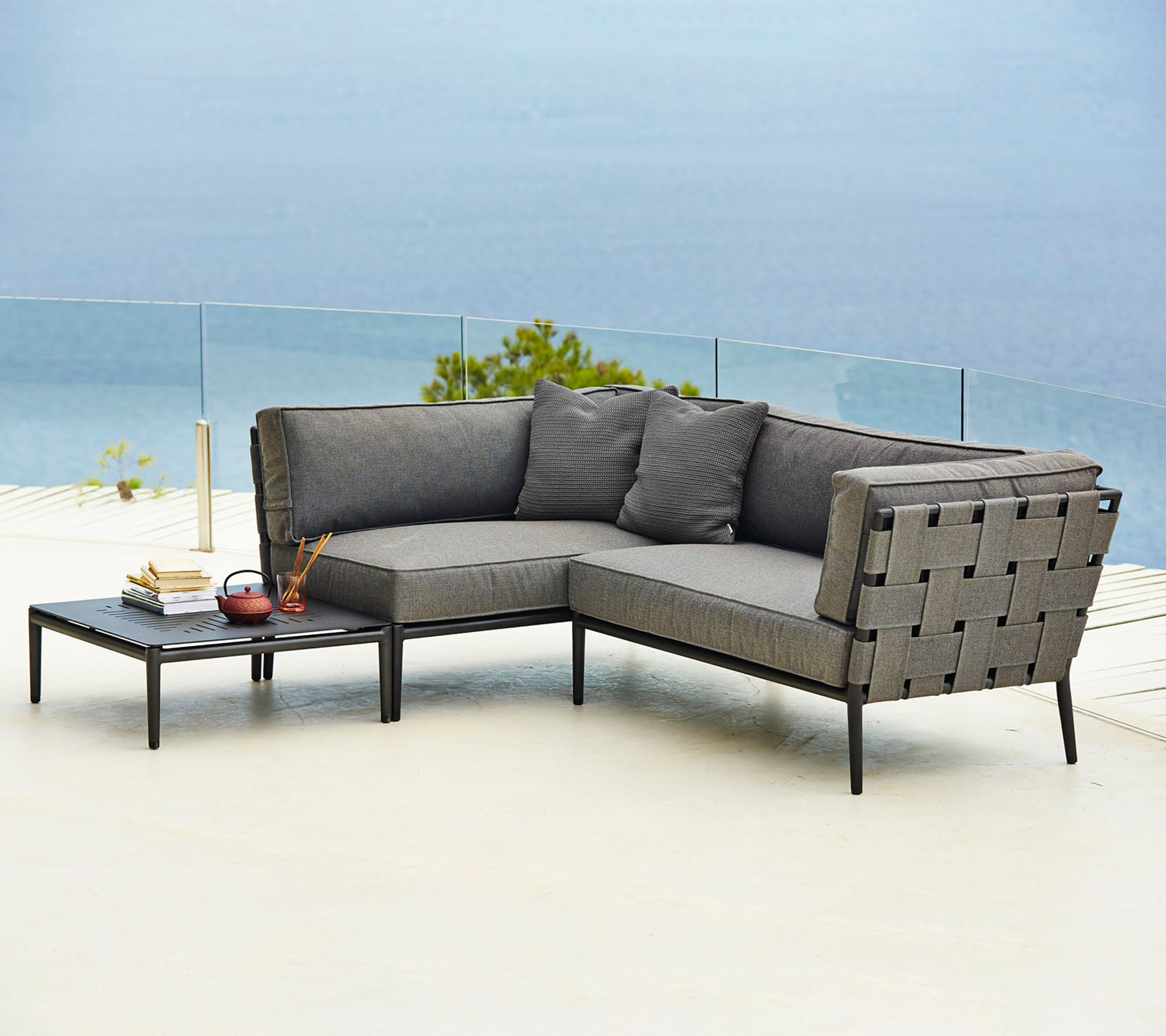 Canapé sectionnel d'extérieur élégant avec des coussins confortables et une table d'appoint assortie, parfait pour se détendre et profiter.