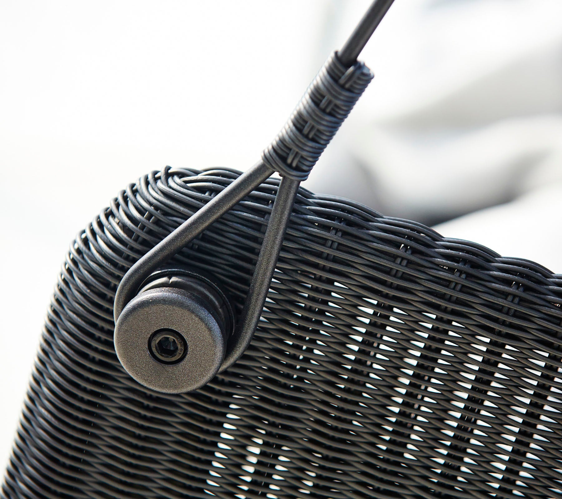 Gros plan d'une texture tissée avec un fermoir circulaire, présentant un élément de design épuré.