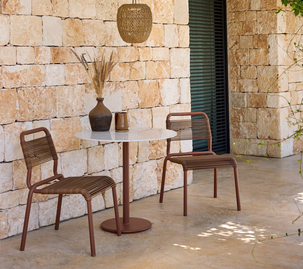 Configuration de salon moderne avec des chaises brunes et une table blanche.