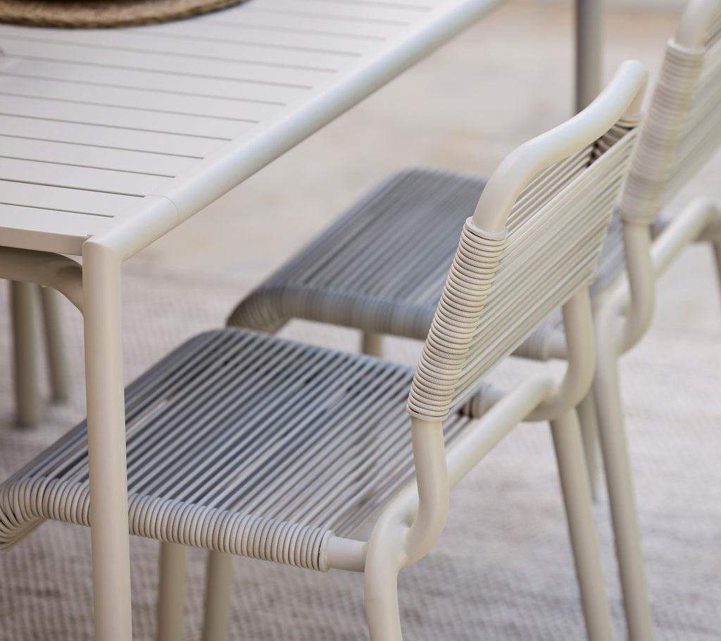 Table à manger moderne avec finition blanche et chaises grises.