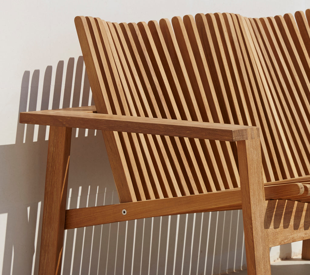 Vue latérale d'un canapé 2 places élégant avec un dossier à lattes et des accoudoirs en bois, mettant en avant un design moderne.