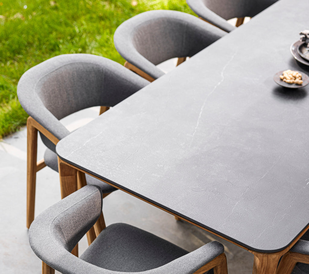 Table à manger élégante avec une surface lisse, entourée de chaises Luna confortables avec un rembourrage doux et des pieds en bois.